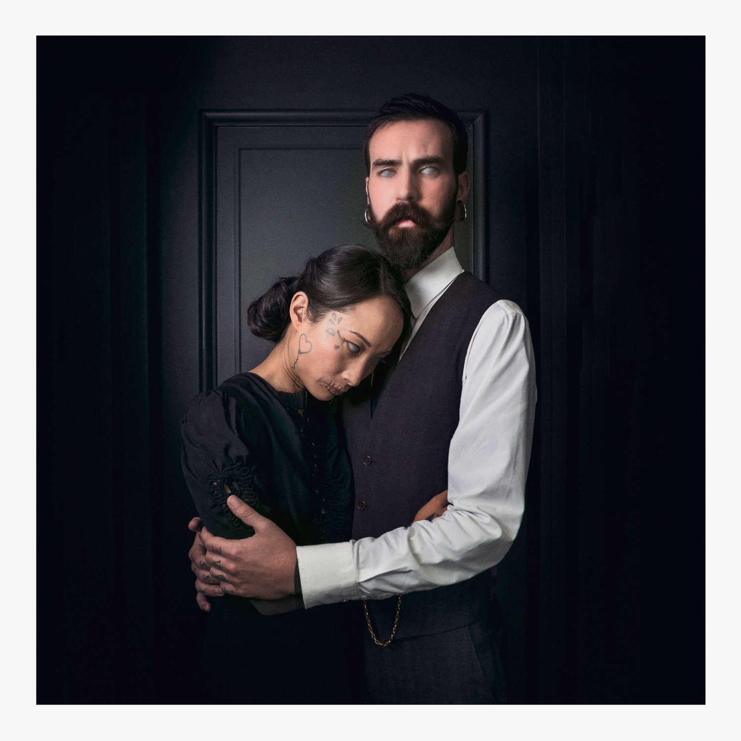 Maniac d'Eric CANTO : couple enlacé aux yeux blancs devant une porte sombre, tirage 70×70